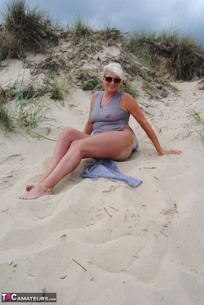 Mature platinum blonde Dimonty models at the beach in see through clothing - #1