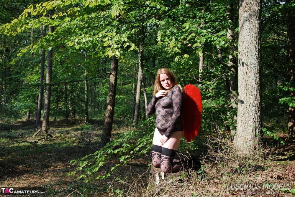 Redheaded amateur models lingerie and angel wings plus stockings in the woods - #2