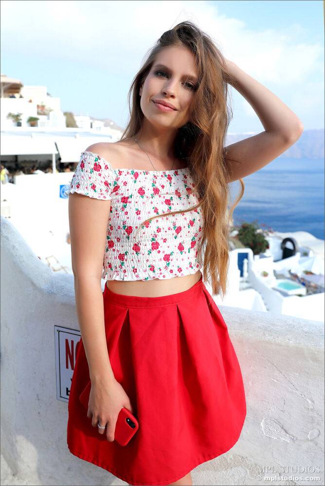 Pretty girl models fully clothed in a red skirt while on vacation - #4