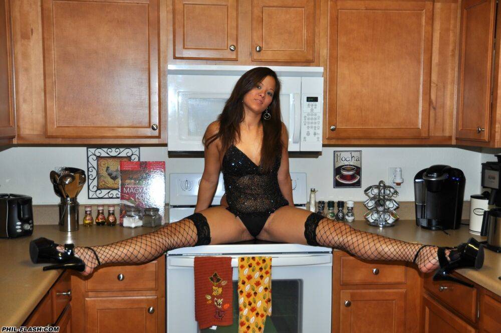 Amateur girl models black lingerie and fishnet stockings on a kitchen counter - #10