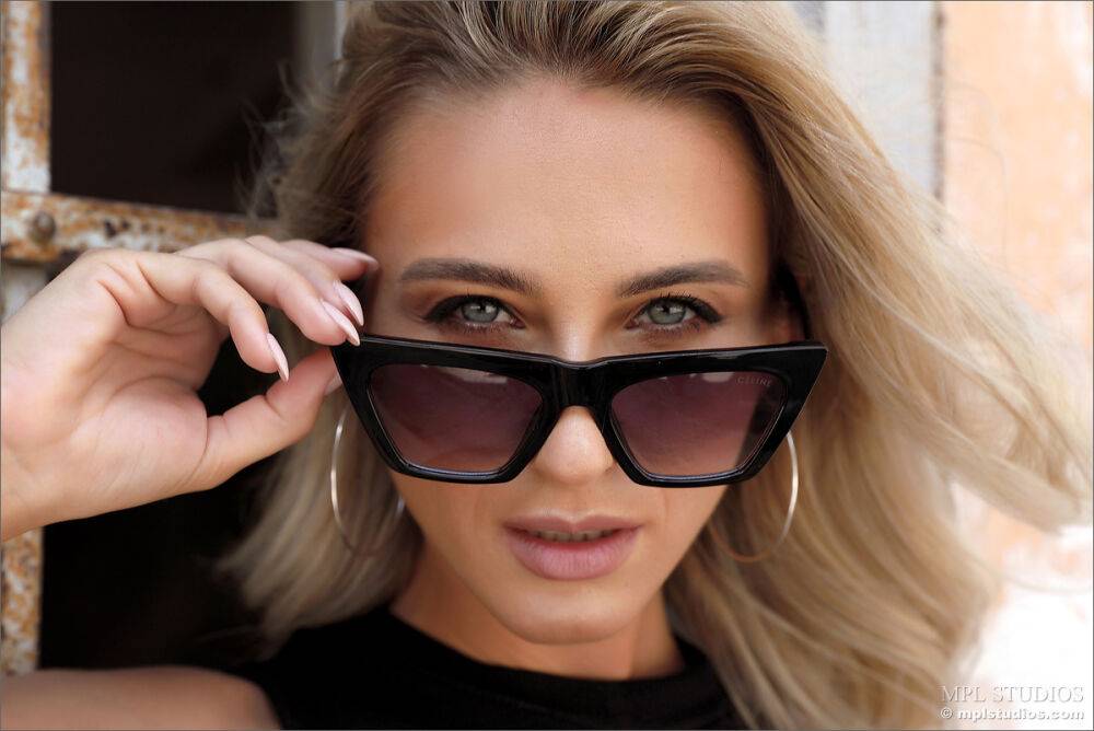 Blonde chick models in a miniskirt and shades during a SFW solo engagement - #9