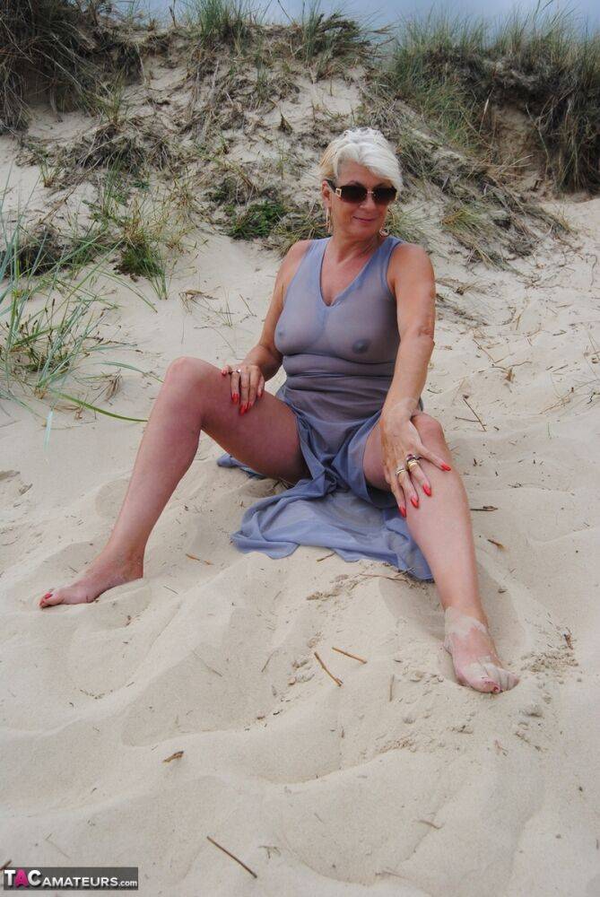 Older blonde amateur Dimonty models at the beach in see thru attire and shades - #9