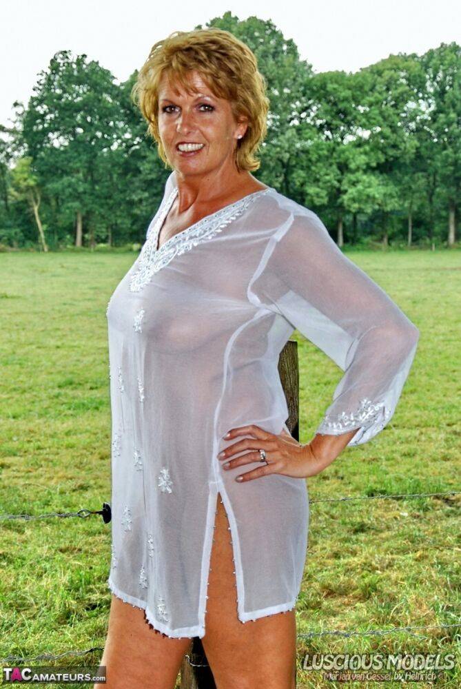 Mature lady exposes her great body by a post in a field in a pair of heels - #3