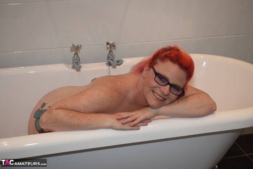 Tattooed redhead Mollie Foxxx models completely naked in a bathroom | Photo: 2681193
