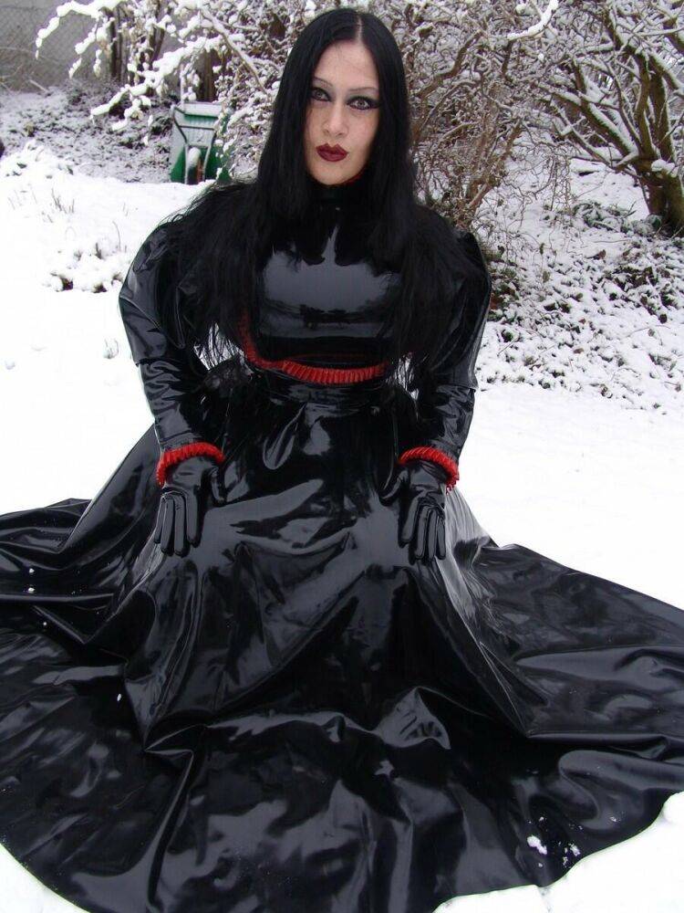 Goth woman Lady Angelina models a black latex dress on snow-covered ground - #16