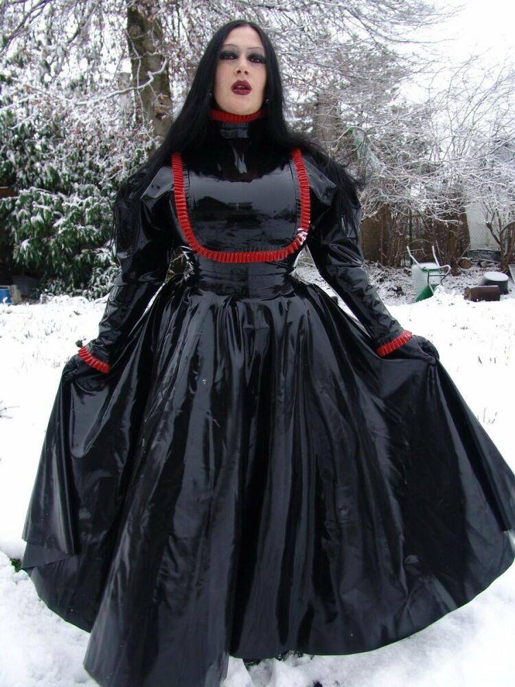 Goth woman Lady Angelina models a black latex dress on snow-covered ground - #12