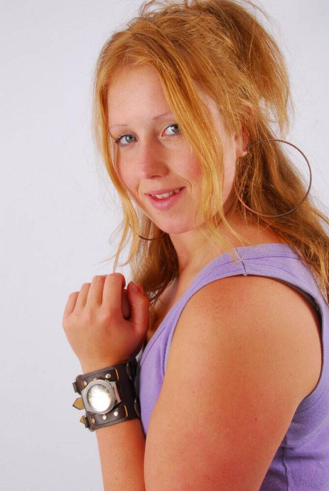 Natural redhead models a large cuff watch in a tank top and faded jeans - #2