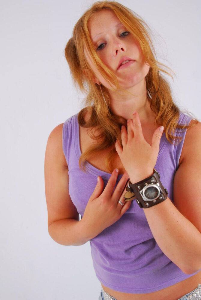 Natural redhead models a large cuff watch in a tank top and faded jeans - #10