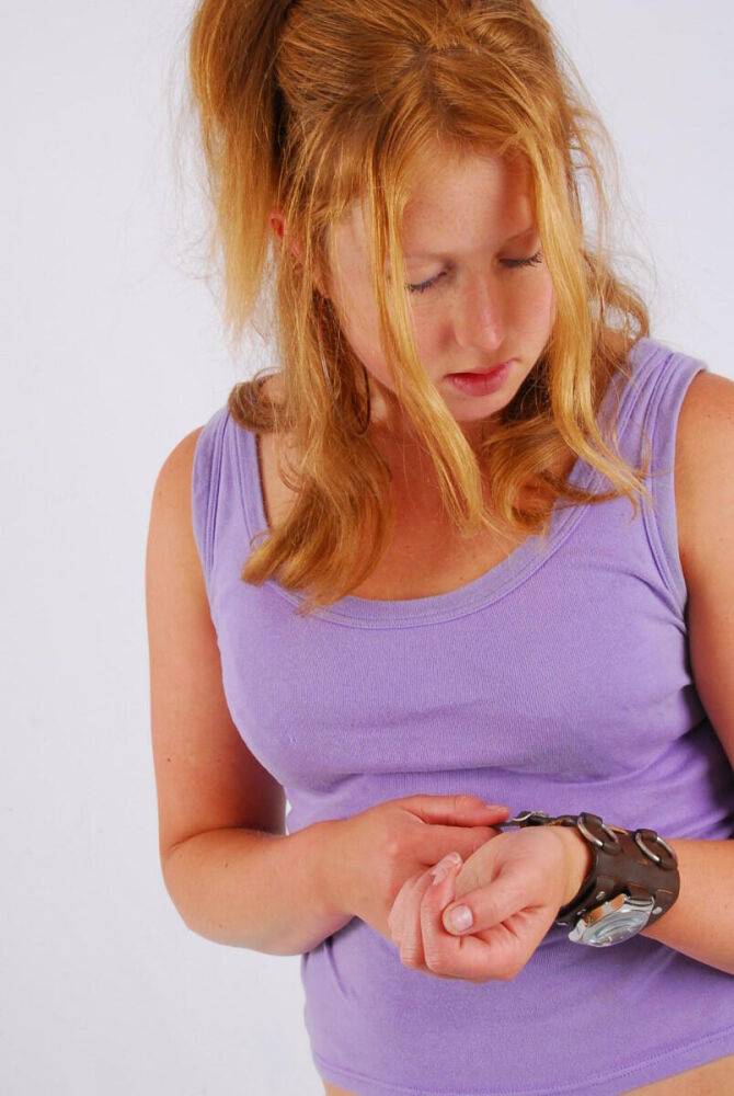 Natural redhead models a large cuff watch in a tank top and faded jeans - #7