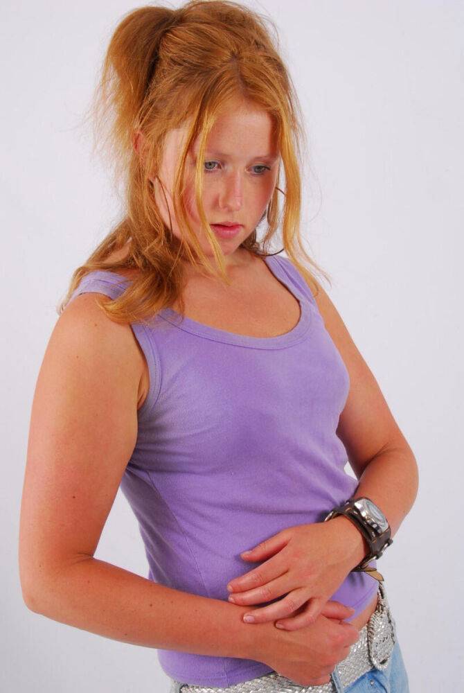 Natural redhead models a large cuff watch in a tank top and faded jeans - #3