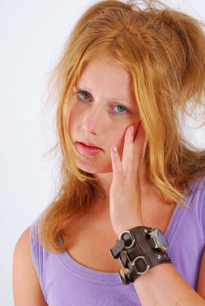 Natural redhead models a large cuff watch in a tank top and faded jeans - #16