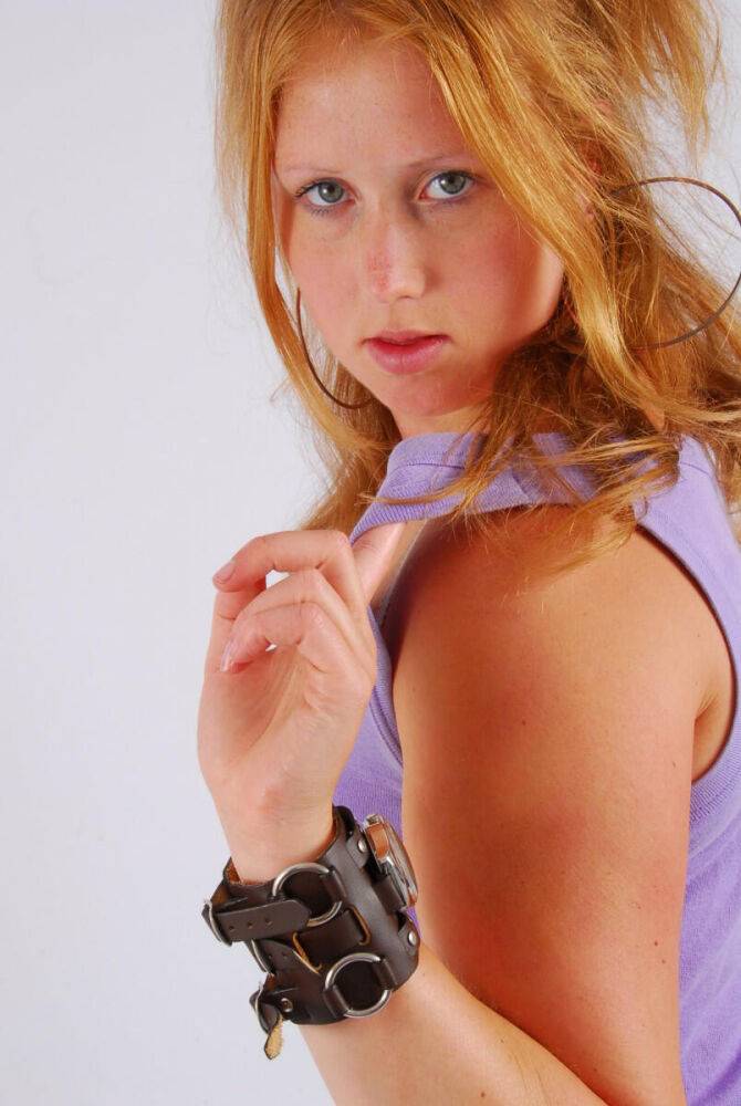 Natural redhead models a large cuff watch in a tank top and faded jeans - #6