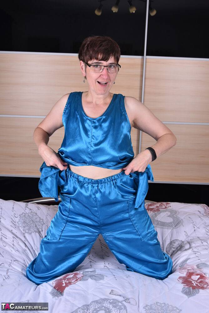 Amateur woman models satin evening wear on a bed with her glasses on - #13