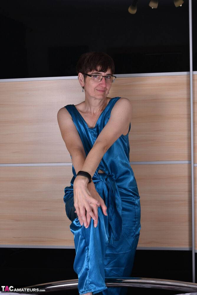 Amateur woman models satin evening wear on a bed with her glasses on - #16