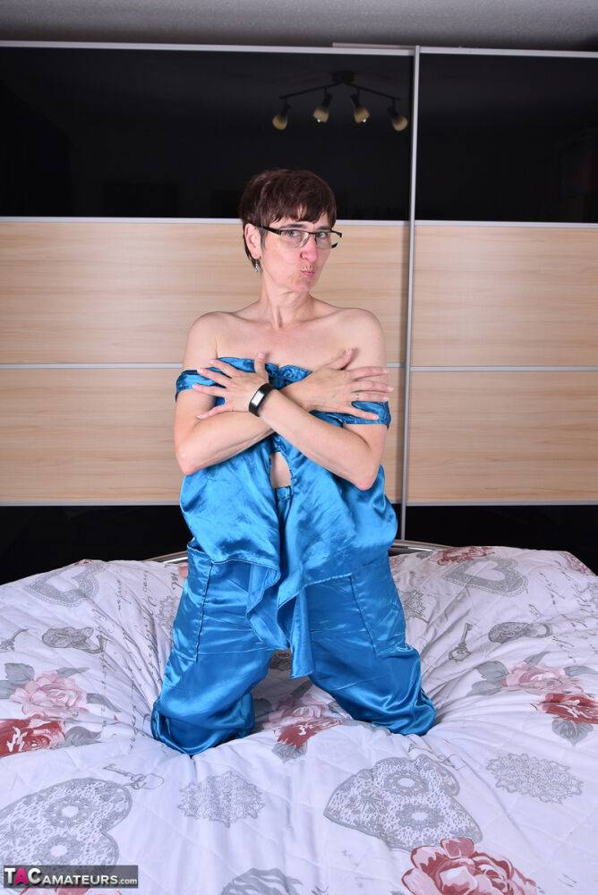 Amateur woman models satin evening wear on a bed with her glasses on - #15