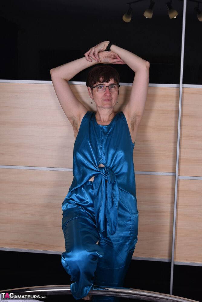 Amateur woman models satin evening wear on a bed with her glasses on - #5