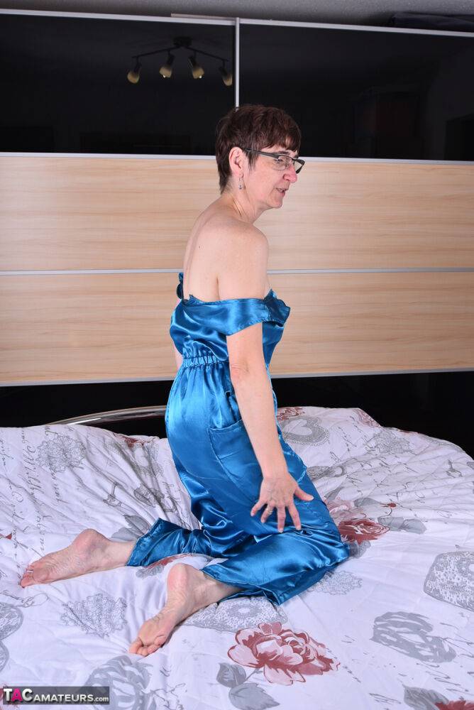 Amateur woman models satin evening wear on a bed with her glasses on - #8