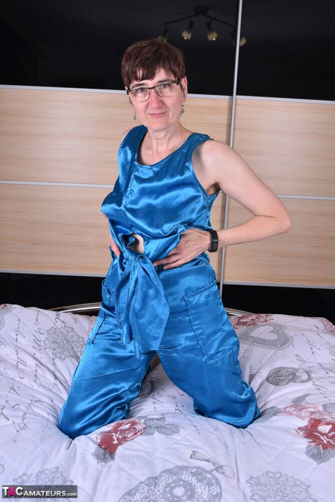 Amateur woman models satin evening wear on a bed with her glasses on - #3