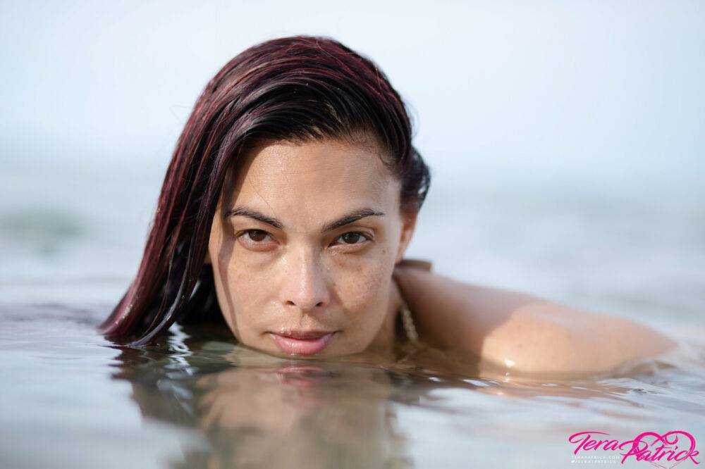 Asian chick Tera Patrick models in the ocean while wearing a gold bikini - #9