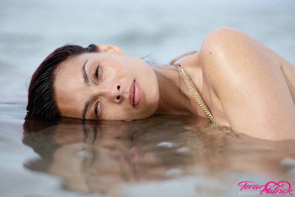 Asian chick Tera Patrick models in the ocean while wearing a gold bikini - #2