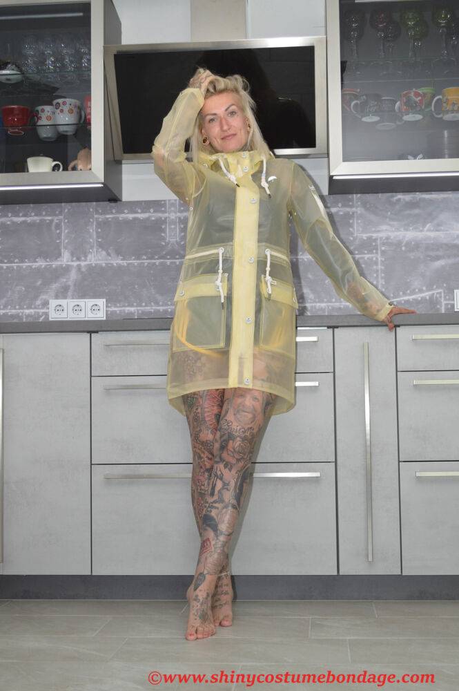 Tattooed blonde Miss Francine models barefoot in a raincoat over rubber wear - #14