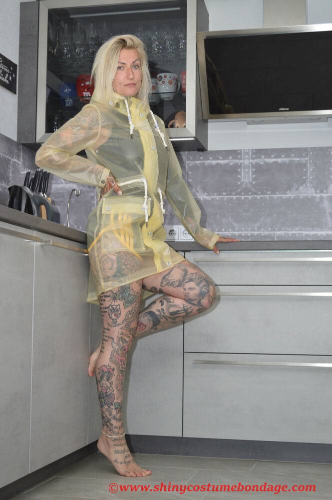 Tattooed blonde Miss Francine models barefoot in a raincoat over rubber wear - #10