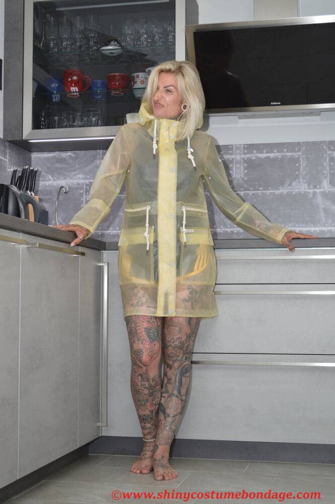 Tattooed blonde Miss Francine models barefoot in a raincoat over rubber wear - #5