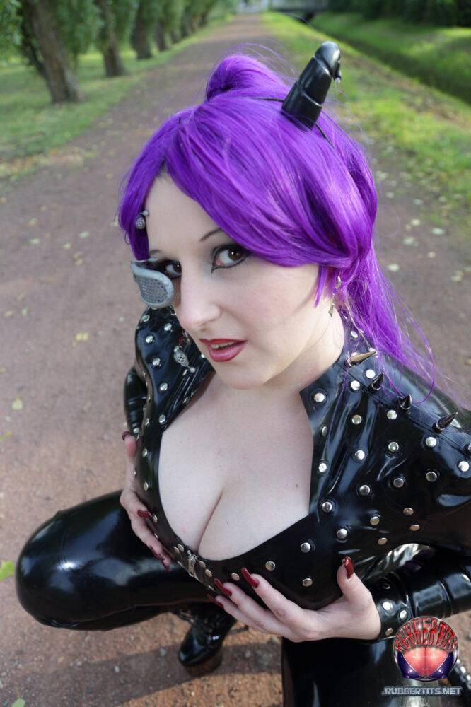 Solo girl with dyed hair models a full body latex outfit in a park - #13