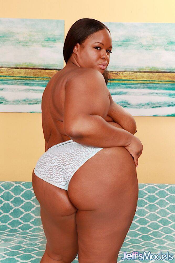 Obese black lady Olivia Leigh holds her big ass after getting naked on a futon | Photo: 2712047