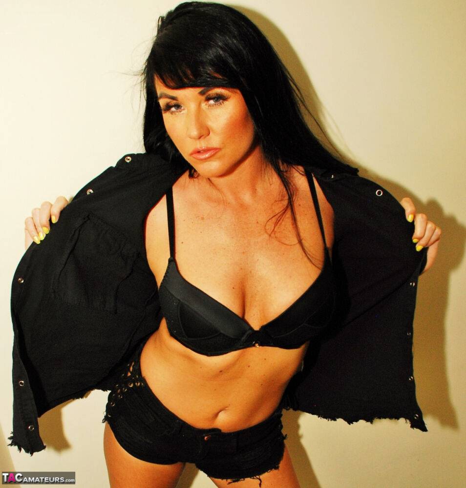 Dark-haired MILF Raunchy Raven models a black bra and shorts in leather boots - #10