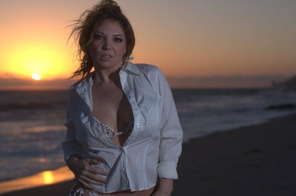 Middle-aged woman Kiki Daire models a blouse and bikini on a beach at sunset - #10