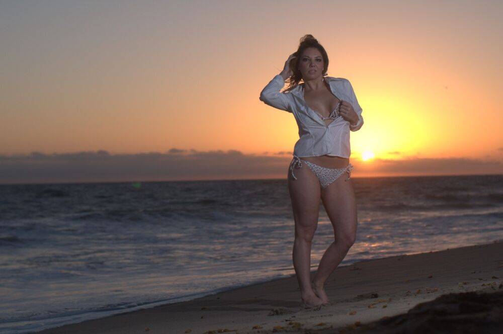 Middle-aged woman Kiki Daire models a blouse and bikini on a beach at sunset - #3