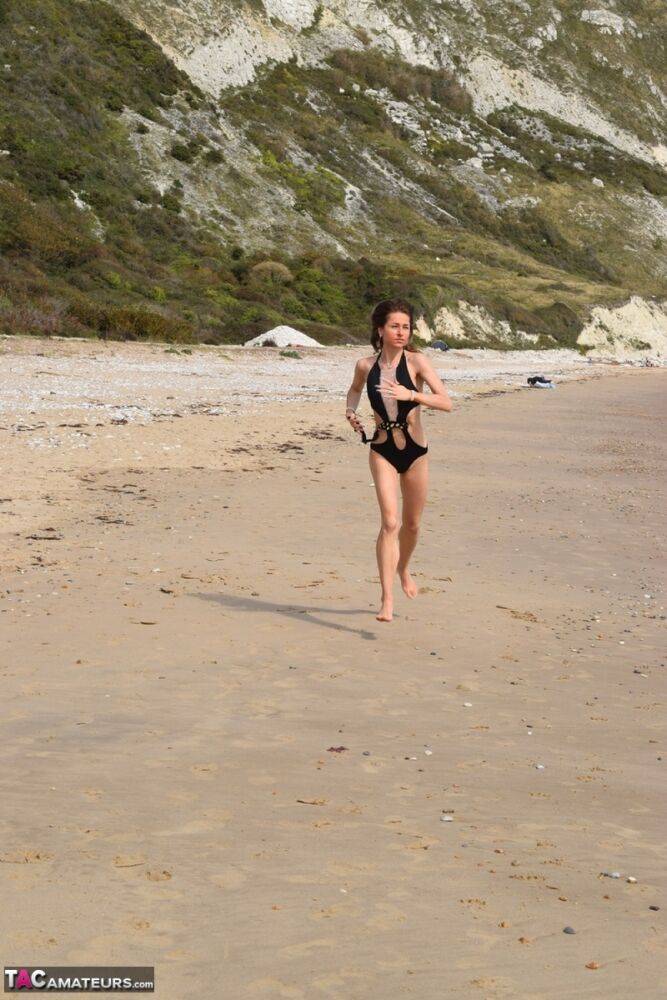 Slender female models a bathing suit while at a deserted beach - #15