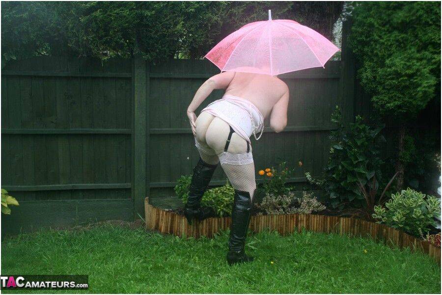 Older redhead Valgasmic Exposed models nude in the rain while holding a brolly - #8