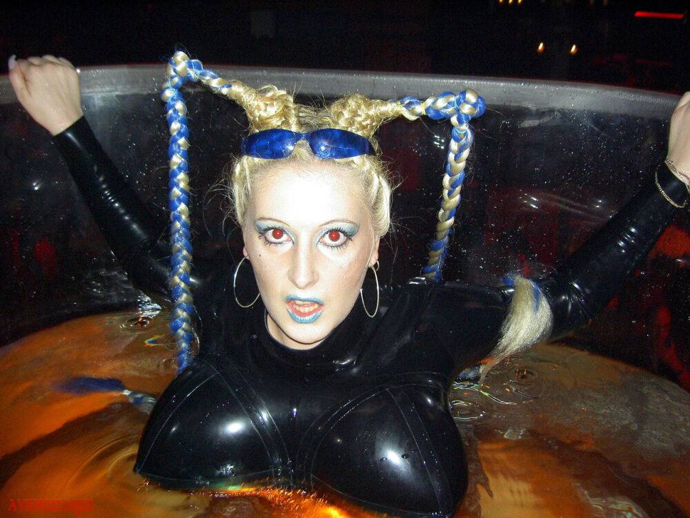 Caucasian female Dark Wing models latex apparel while in a watery cage - #9