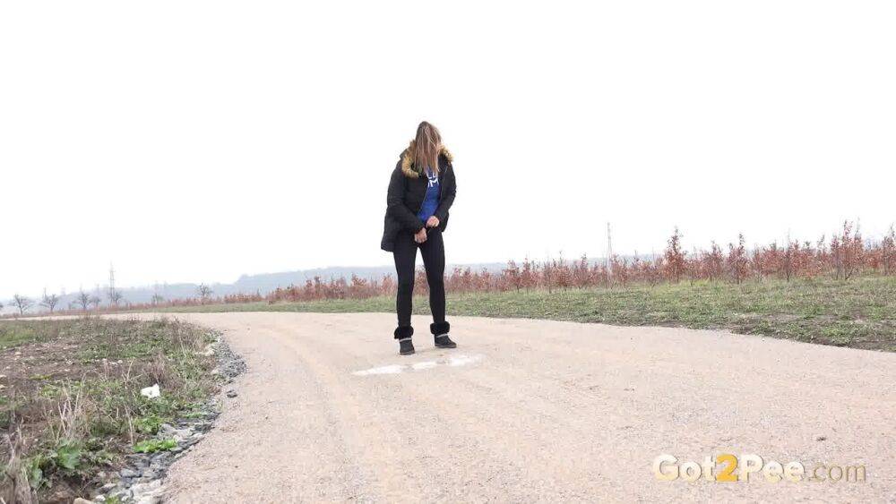 Fully clothed girl Naomi Bennet pulls down her pants to piss on a dirt road - #8