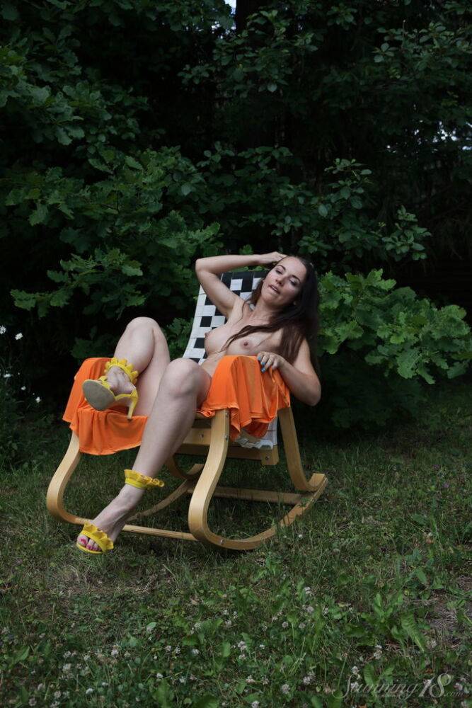 Barely legal brunette Nicole V gets naked on a backyard rocking chair - #1