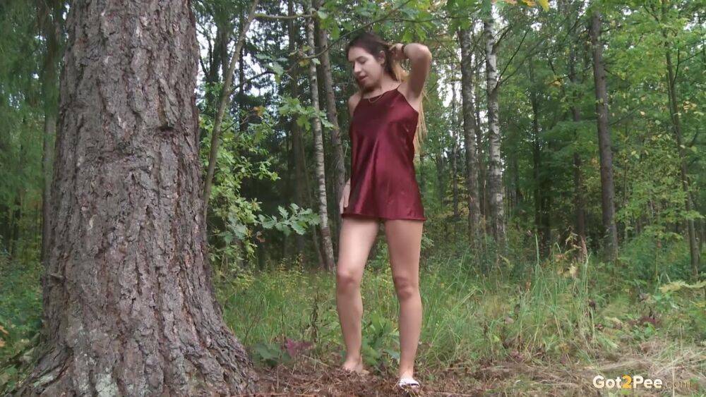 Leggy girl Diana Sweet places a foot against a tree for a piss in the woods - #15