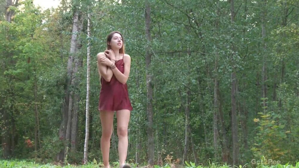 Leggy girl Diana Sweet places a foot against a tree for a piss in the woods - #7