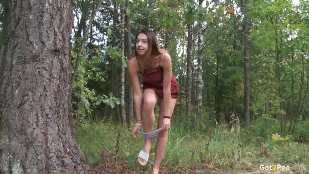 Leggy girl Diana Sweet places a foot against a tree for a piss in the woods - #8