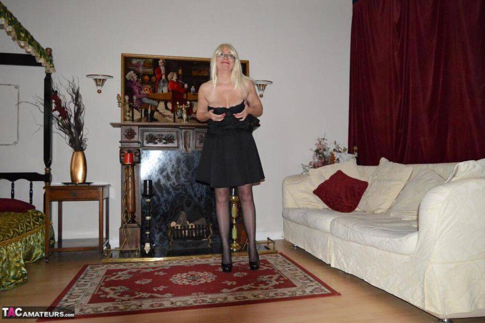 Mature blonde Barby Slut gets naked on a sofa in garters and nylons - #7