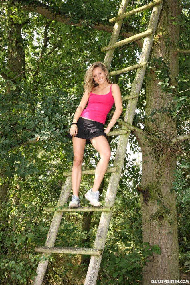 Young blonde girl Nessy strips naked on a treehouse ladder - #11