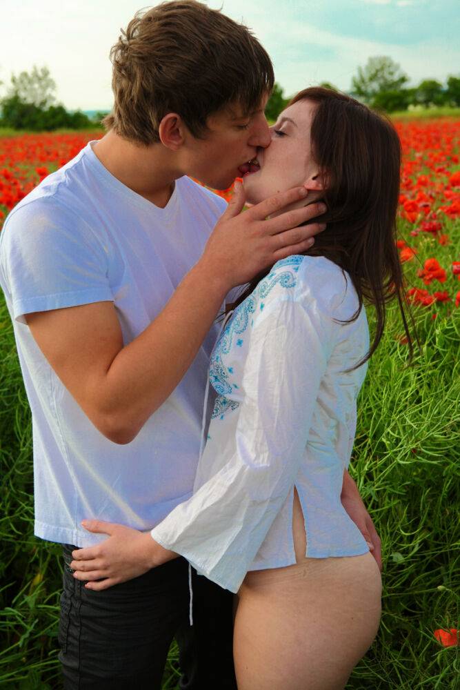Young couple has sexual intercourse in a field of blooming poppies - #6