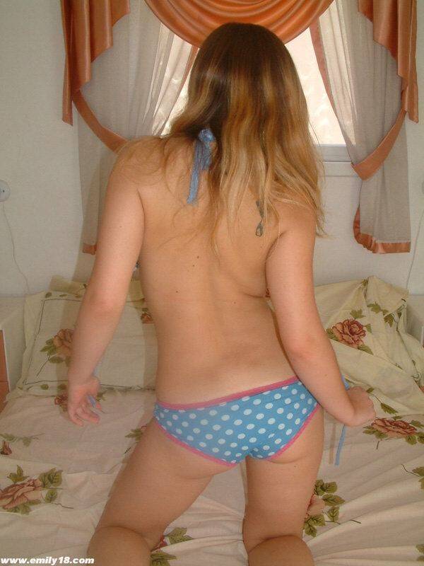 Cute young girl pulls down her cute panties to show her ass crack on a bed - #14