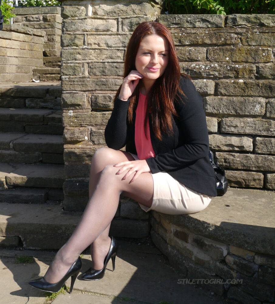 Clothed redhead Sara shows off her black heels on a sidewalk in hosiery - #2