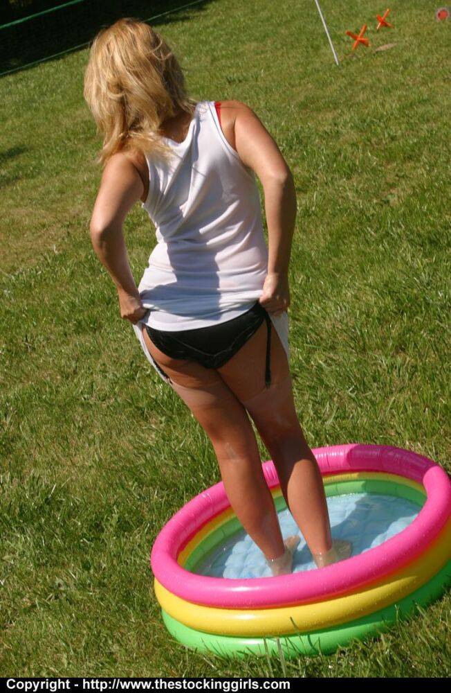 Amateur chick stands in a wading pool while baring her panties in nylons - #11