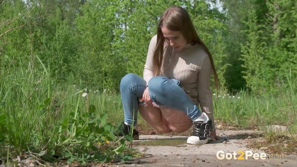 Solo girl Nastya pulls down tight jeans to pee on an old pad in a field - #11