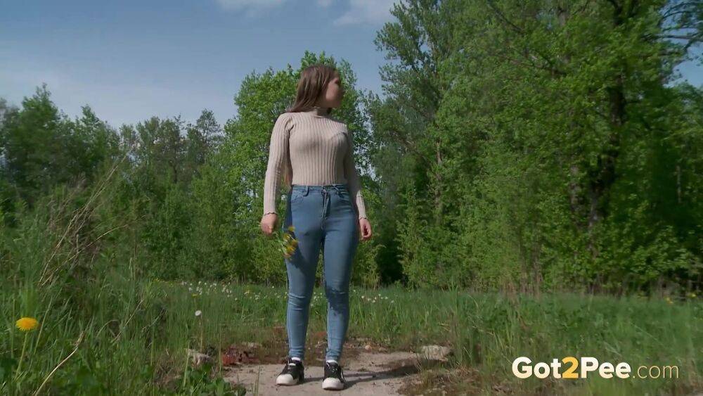 Solo girl Nastya pulls down tight jeans to pee on an old pad in a field - #13