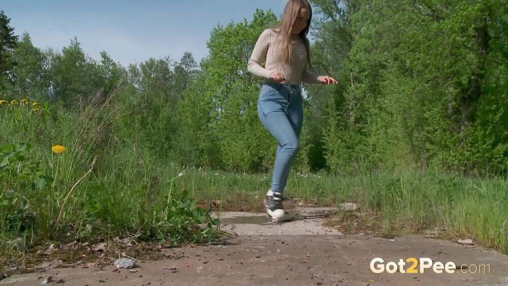 Solo girl Nastya pulls down tight jeans to pee on an old pad in a field - #1