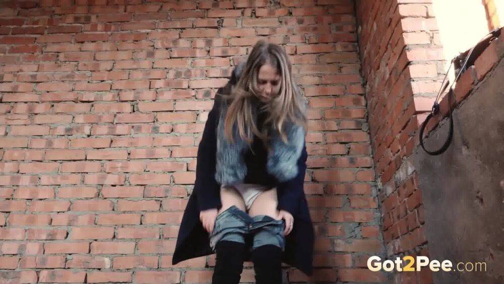 Distressed girl squats for an outdoor piss while wearing a heavy winter coat - #1